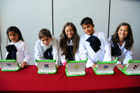 Nenas y nenes con un ordenador portátil proporcionado por el Plan Ceibal.