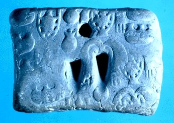 Impressed tablet showing one circular marking and two wedges.