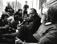 Lluís Maria Xirinacs sentado en el suelo, delante de la prisión Modelo, con los «captaires de la pau» («mendigos de la paz»).